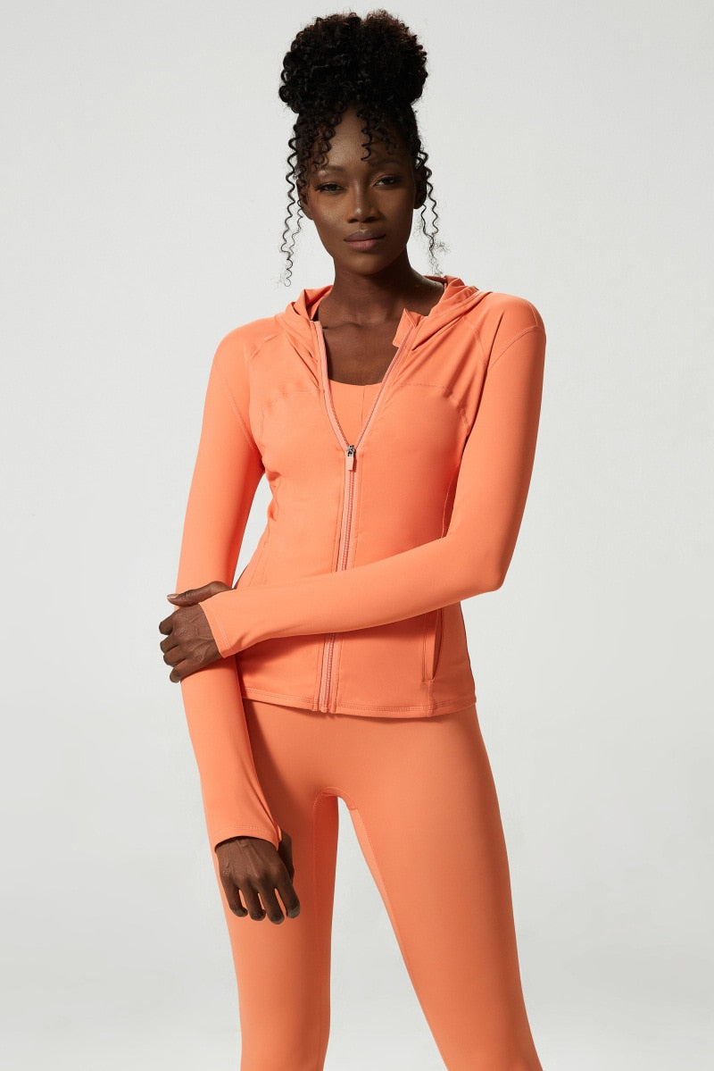 Women's hooded workout jacket with thumb holes, long sleeves, and breathable fabric, perfect for yoga, running, and outdoor activities.