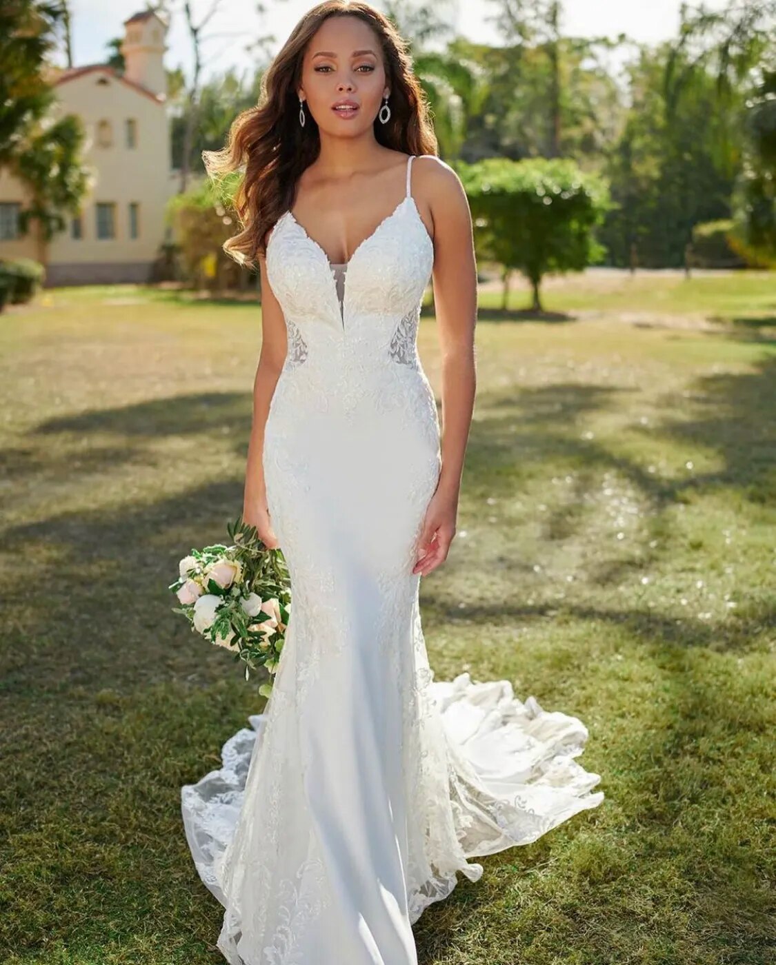 Elegant lace mermaid wedding dress with spaghetti straps, V-neck, backless design, appliques, and a long sweep train from The Clothing Company Sydney.