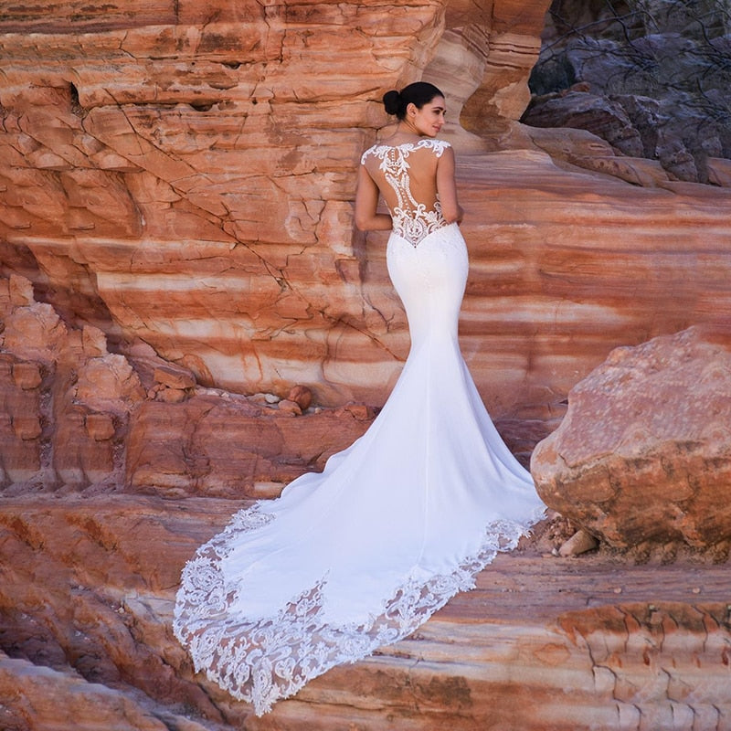 Satin mermaid wedding dress by The Clothing Company Sydney with boho sleeveless V-neck, beaded details, and long train.