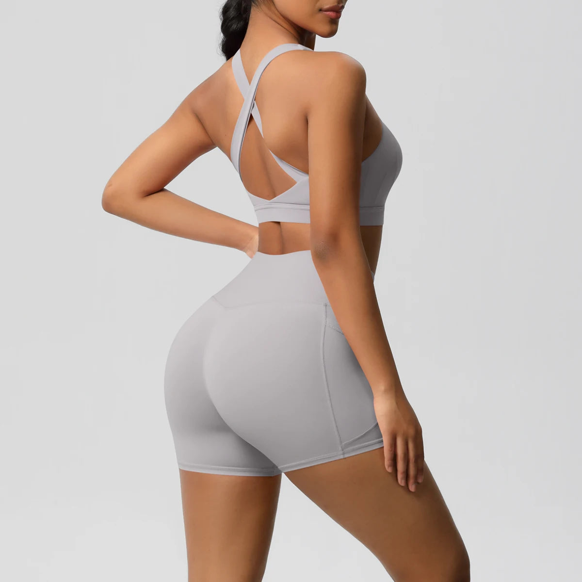 Two-piece women's fitness yoga set with crossover bra, pocketed gym shorts, and leggings, from The Clothing Company Sydney.