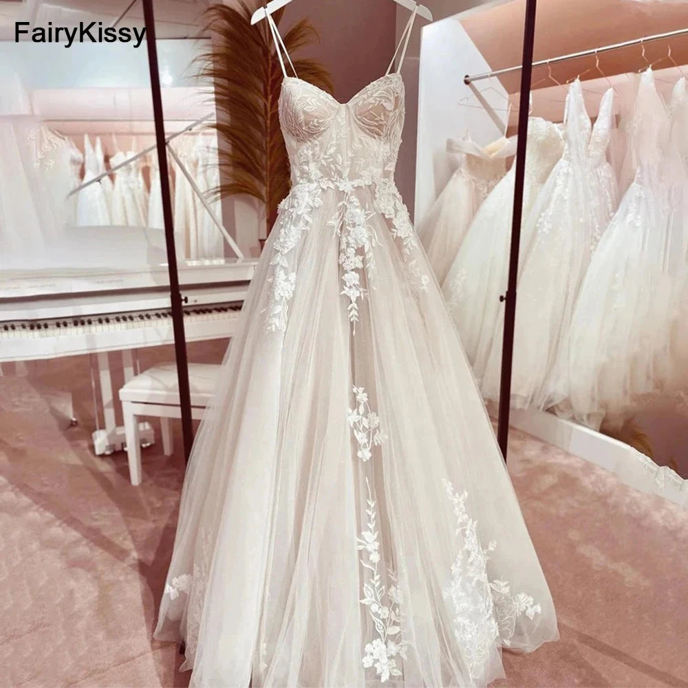Backless wedding dress by The Clothing Company Sydney featuring spaghetti straps, see-through mesh, lace details, and exposed boning.