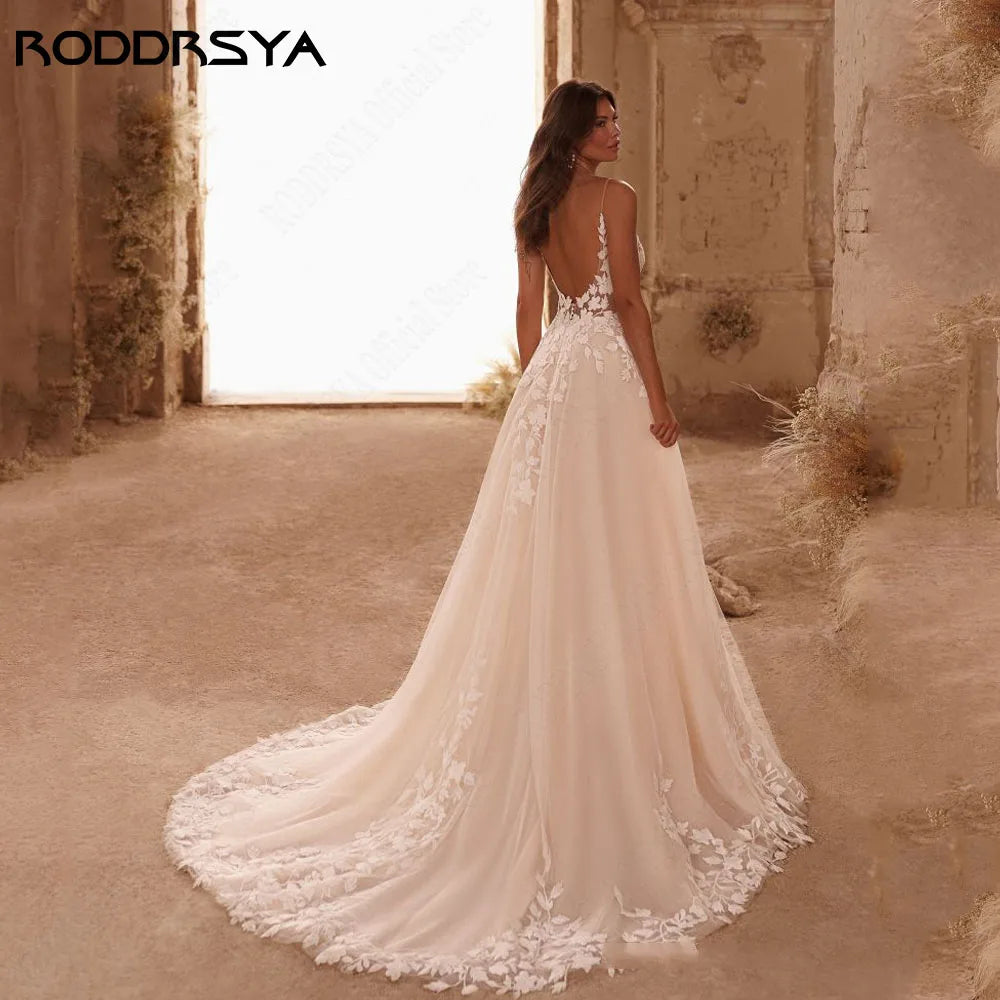 Elegant backless wedding dress with spaghetti straps, glitter V-neck, appliqué details, and sweep train by The Clothing Company Sydney.
