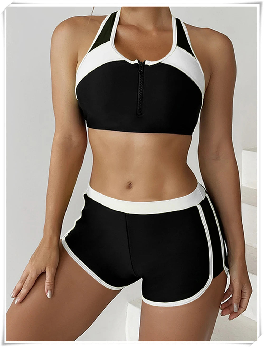 Two-piece swimsuit by The Clothing Company Sydney featuring a zippered tankini top and high-waist swim shorts for summer beachwear.