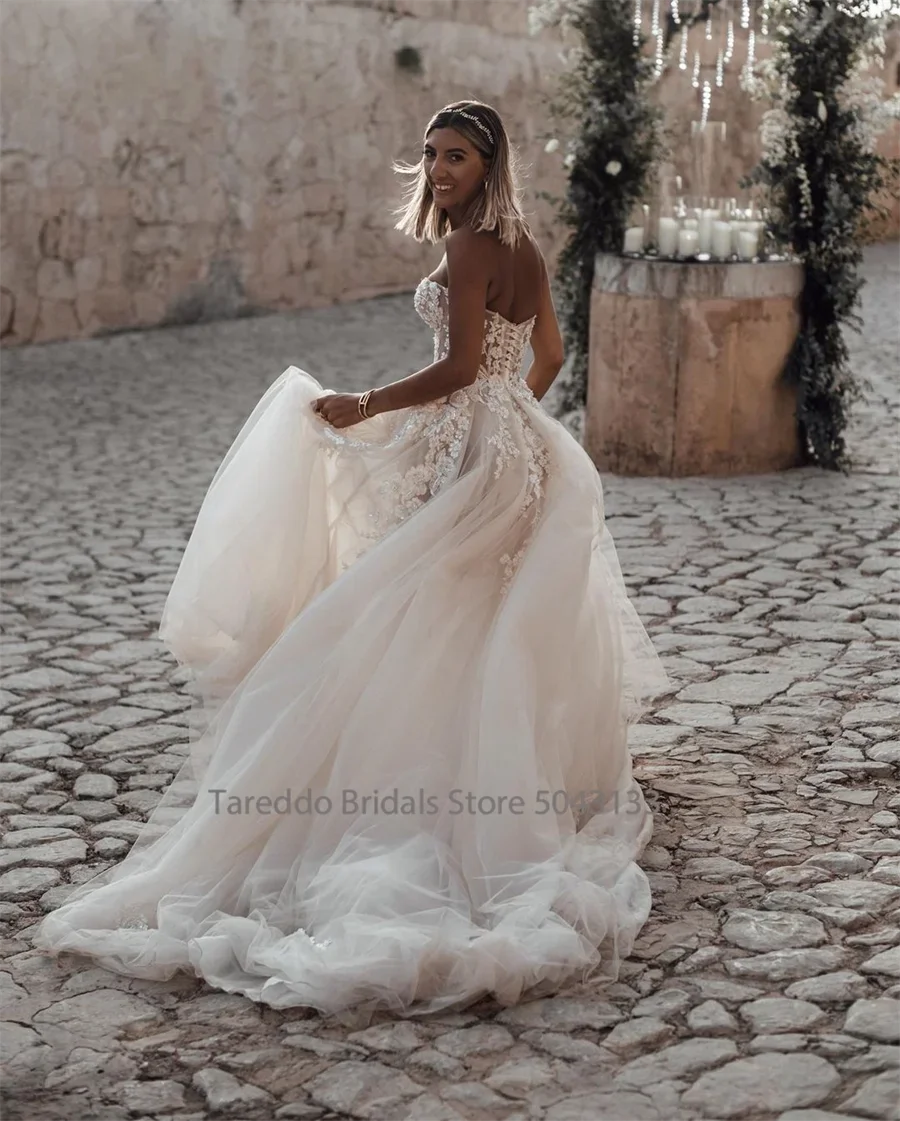Customized strapless wedding dress by The Clothing Company Sydney with crystal lace appliques and flowing silhouette.