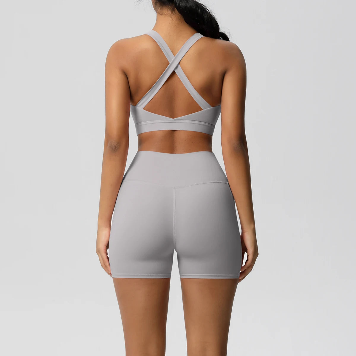 Two-piece women's fitness yoga set by The Clothing Company Sydney, includes crossover bra, sport shorts, and leggings with pockets.