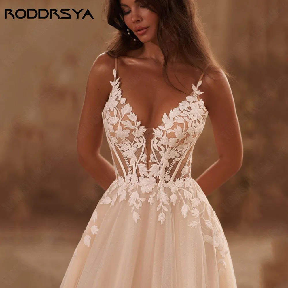 Elegant backless wedding dress with spaghetti straps, glitter V-neck, applique details, and sweeping train by The Clothing Company Sydney.