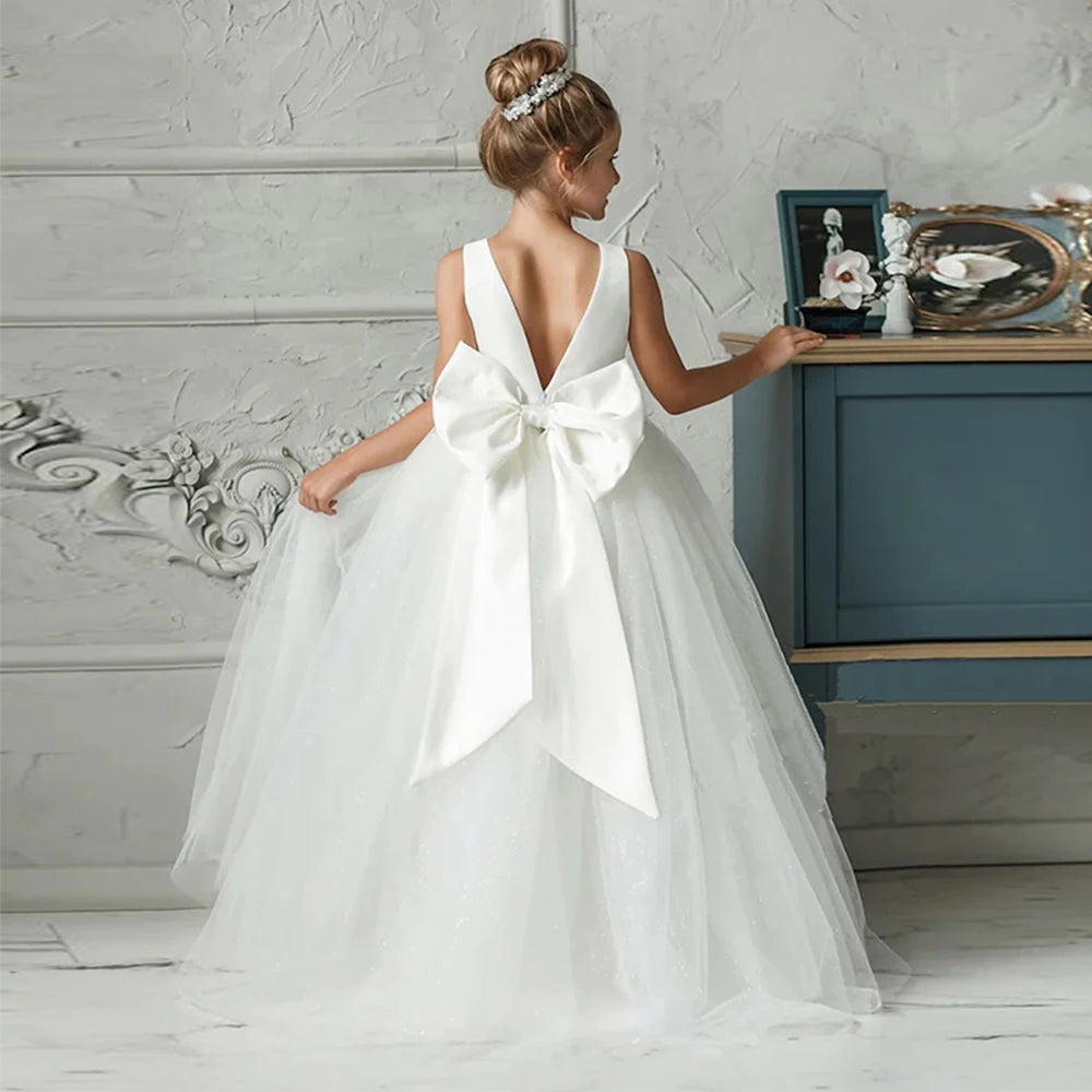 Girls white bridesmaid and prom gown with a large bow, formal evening dress for kids by The Clothing Company Sydney.