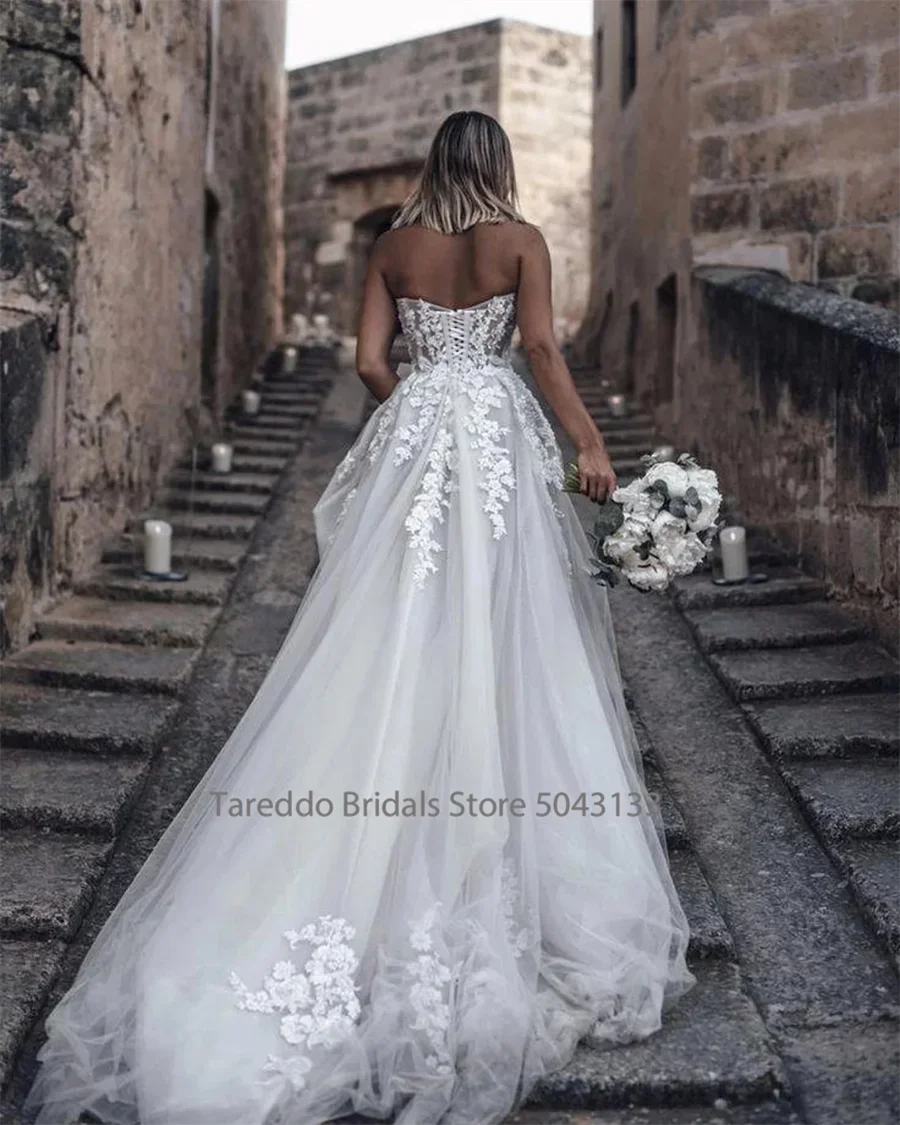Customized strapless wedding dress by The Clothing Company Sydney with crystal lace appliques and a flowy silhouette.