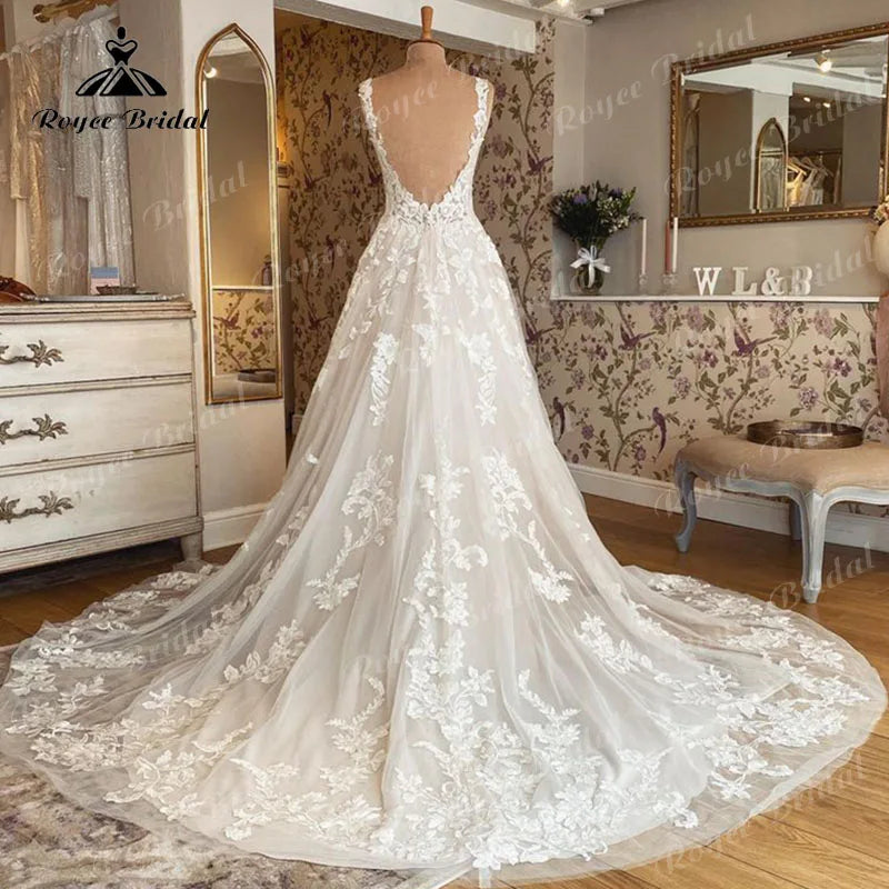 Blush pink sleeveless wedding dress by The Clothing Company Sydney with V-neck, lace appliqué, backless design, A-line silhouette.