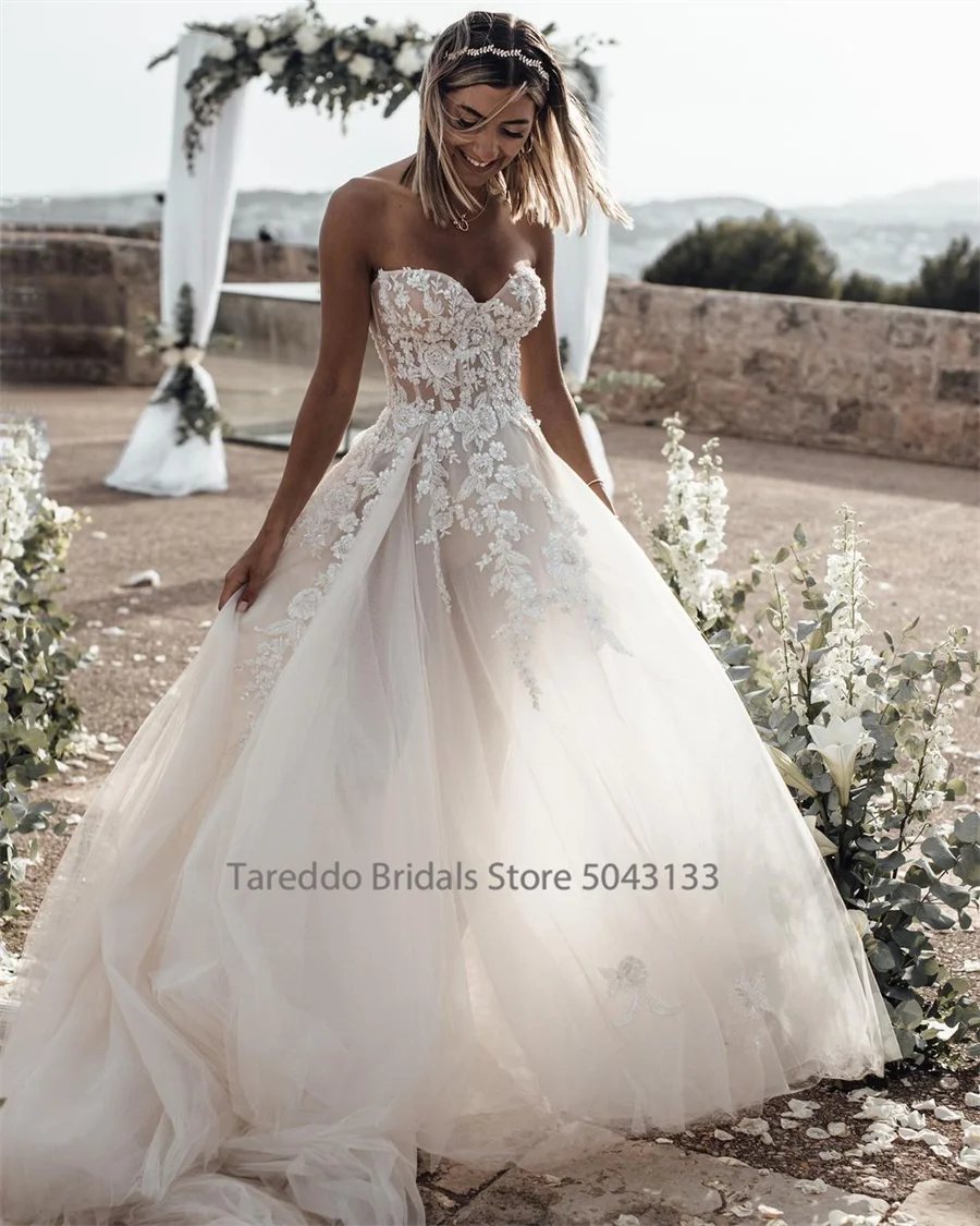 Elegant customized strapless wedding dress by The Clothing Company Sydney with crystal lace appliques and flowing silhouette.