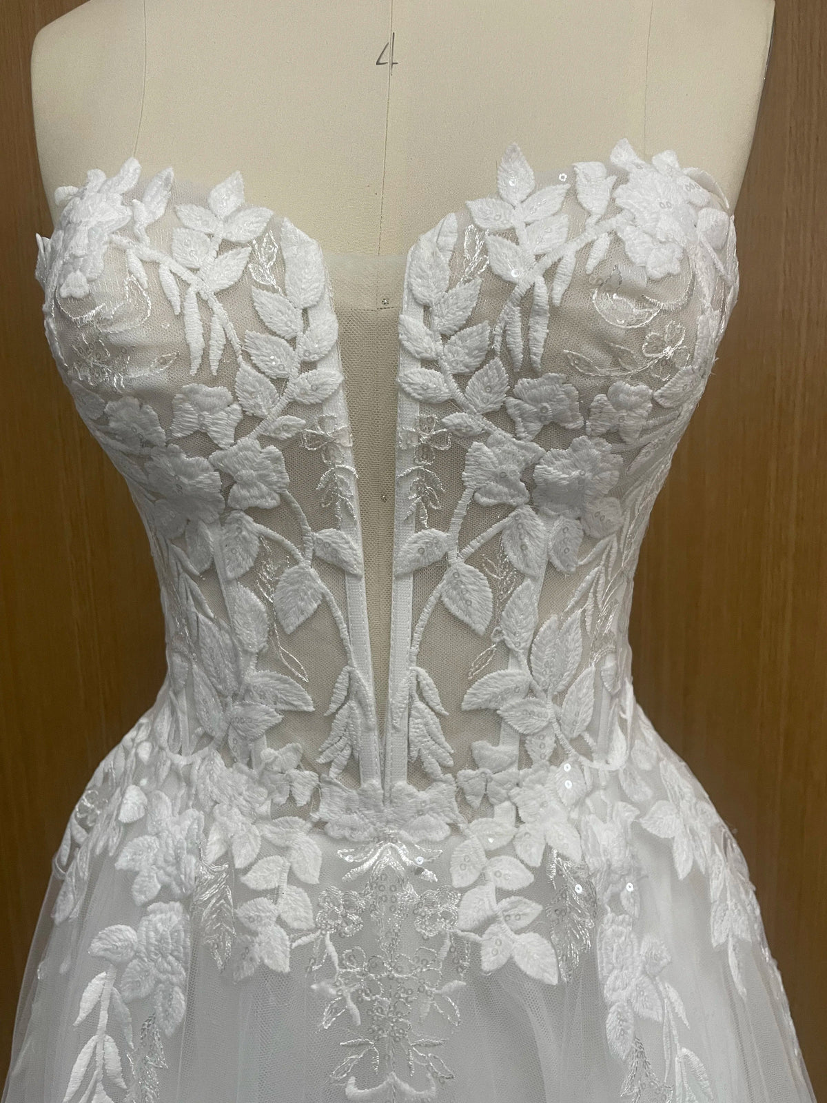Elegant sleeveless lace wedding dress with deep V-neck and sparkle embellishments, designed by The Clothing Company Sydney.