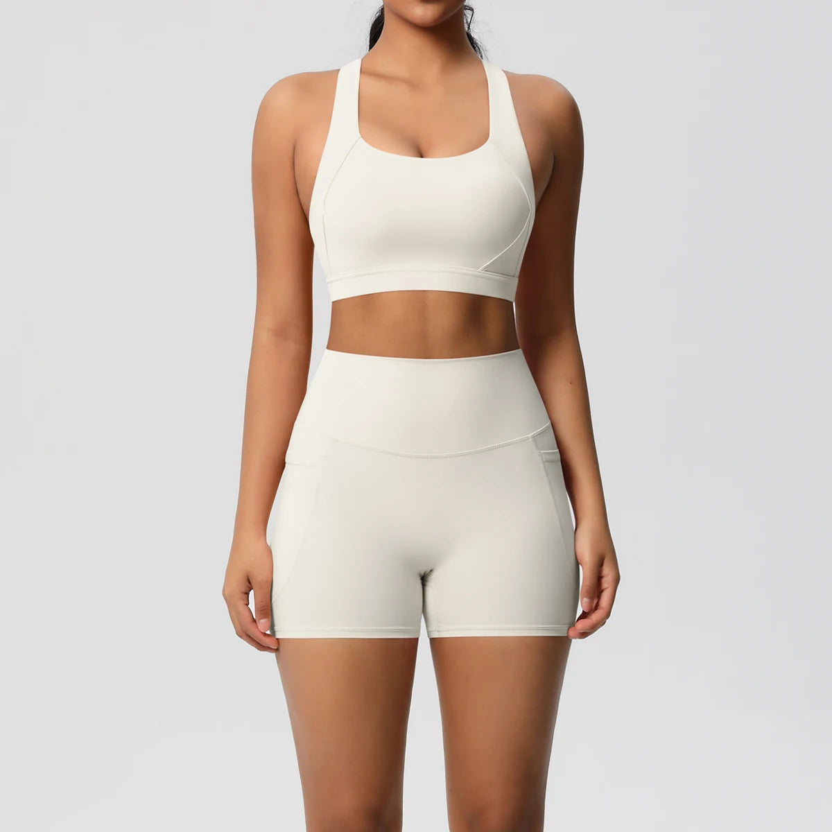 Two-piece women's sportswear yoga set with crossover bra, gym shorts, and leggings, featuring pockets, from The Clothing Company Sydney.