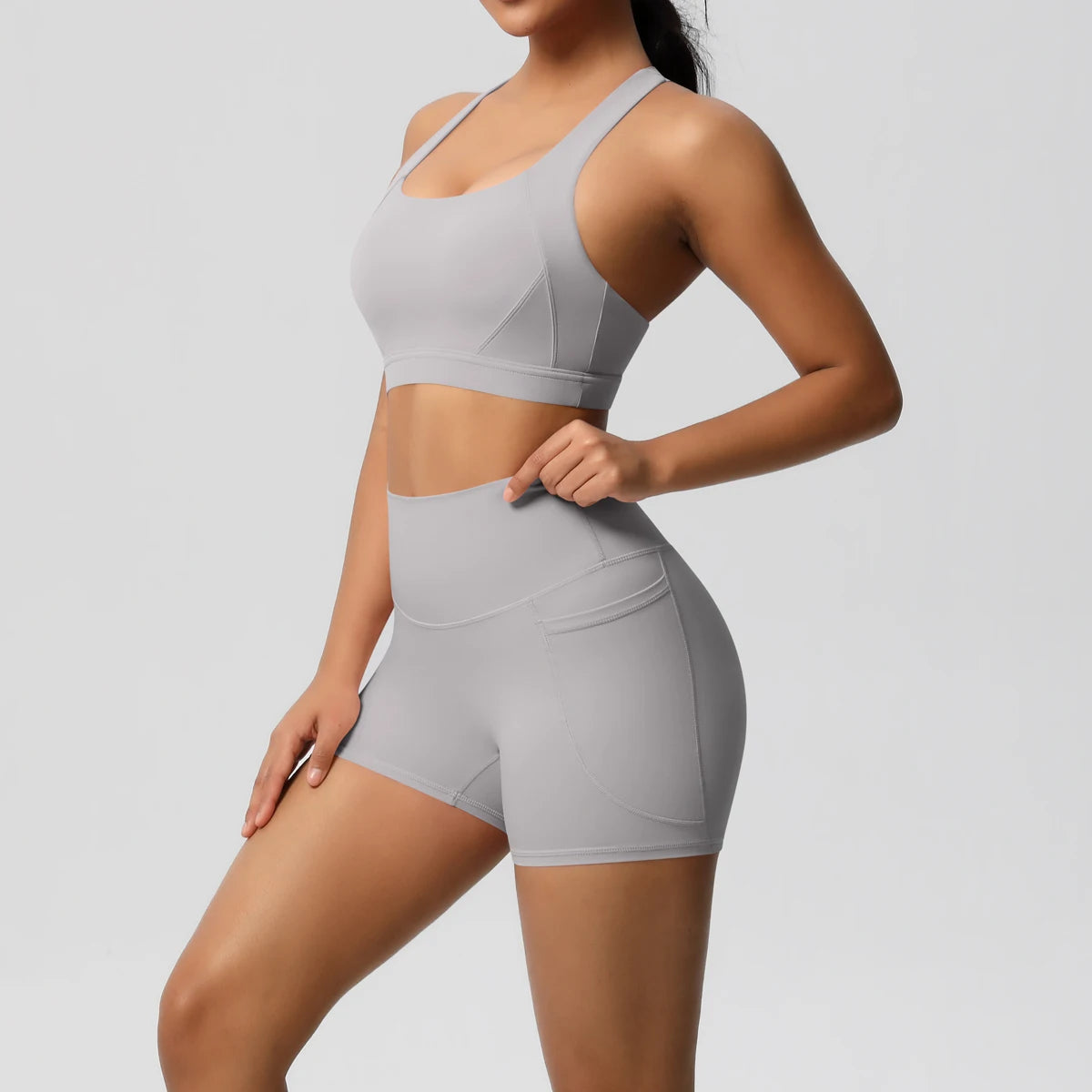 Two-piece women's sportswear set by The Clothing Company Sydney, featuring yoga leggings, crossover bra, and bike shorts for fitness.