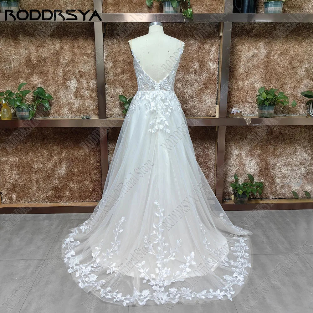 Glitter spaghetti strap wedding dress with V-neck, backless design, applique details, and sweep train by The Clothing Company Sydney