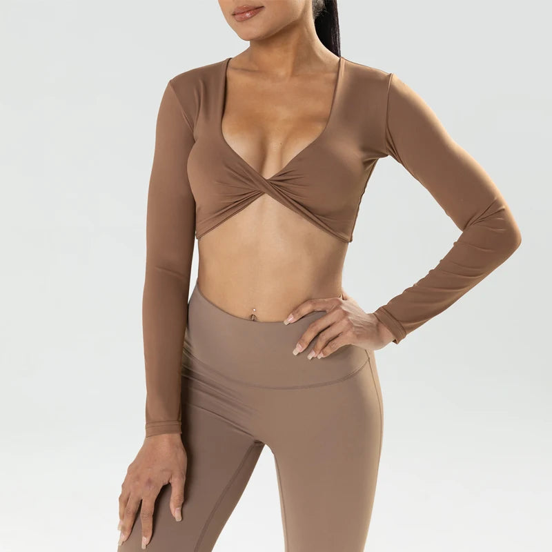 The Clothing Company Sydney long sleeve gym crop top with twist detail, deep V neckline, padded support, and quick-dry fabric for fitness.