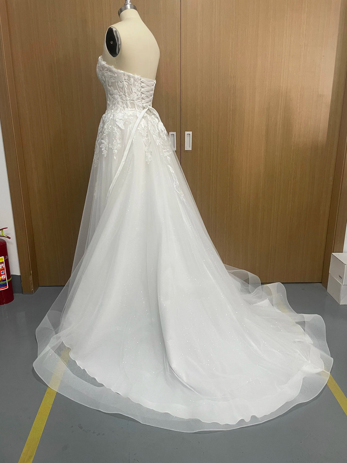 Elegant sleeveless lace wedding dress with deep V-neck and sparkly details, designed by The Clothing Company Sydney.