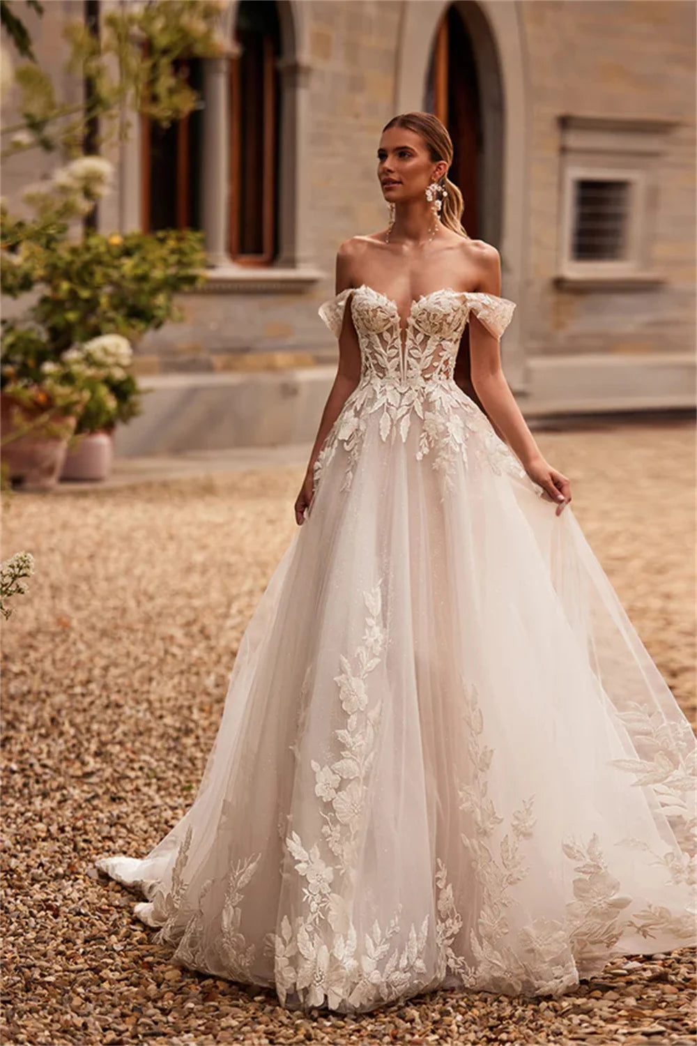 Off-the-shoulder wedding dress with 3D floral lace appliqué and A-line silhouette, custom-made bridal gown by The Clothing Company Sydney
