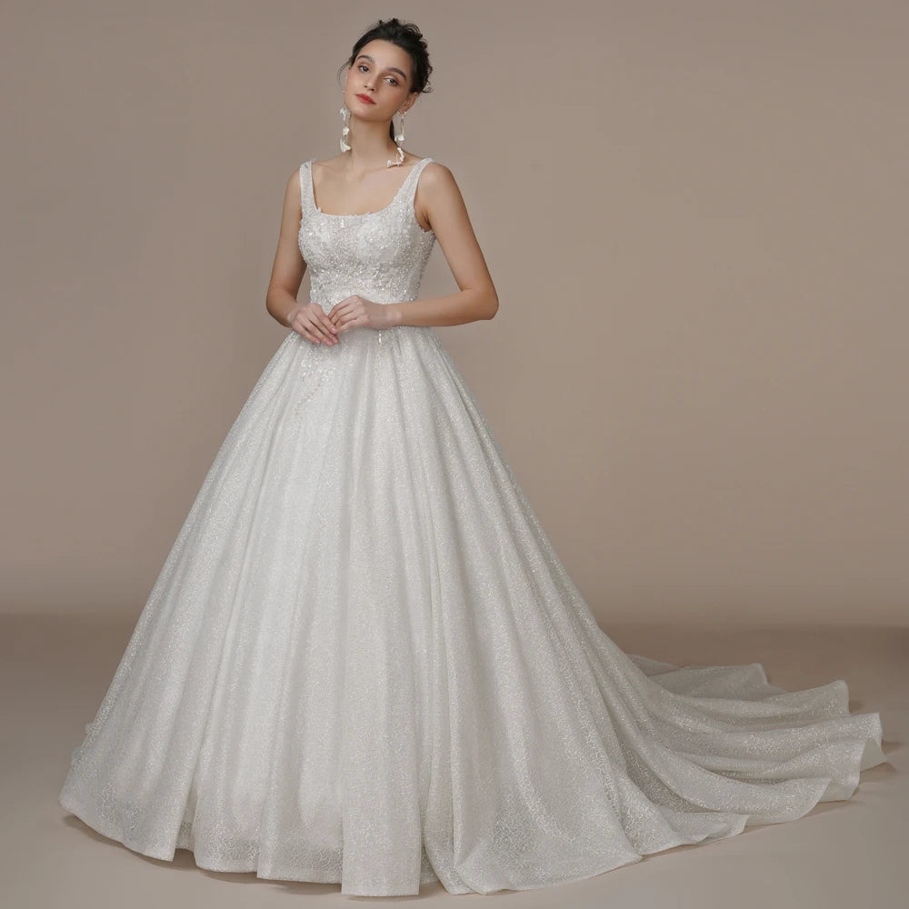 Luxury strapless A-line wedding dress with off-the-shoulder neckline, ivory glitter fabric, featuring bling details for brides.