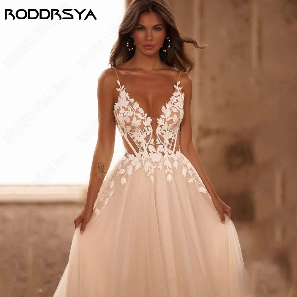Backless boho wedding dress with spaghetti straps, glitter V-neck, appliqué details, and sweep train by The Clothing Company Sydney.