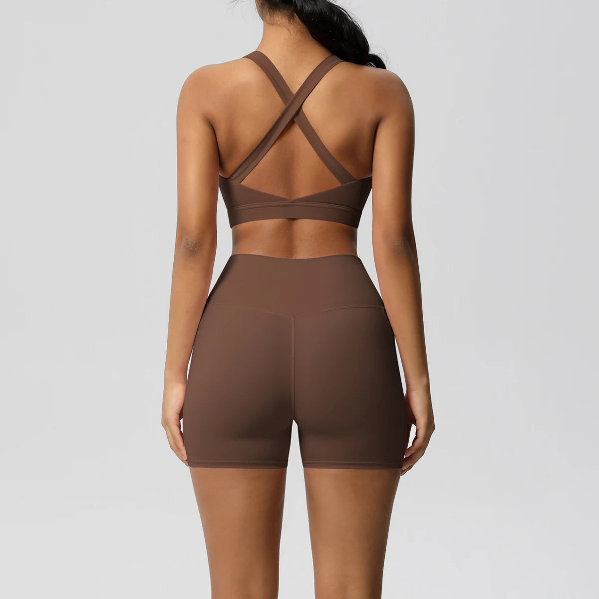 Women’s sportswear set by The Clothing Company Sydney featuring pocketed gym shorts, crossover bra, and leggings for fitness.