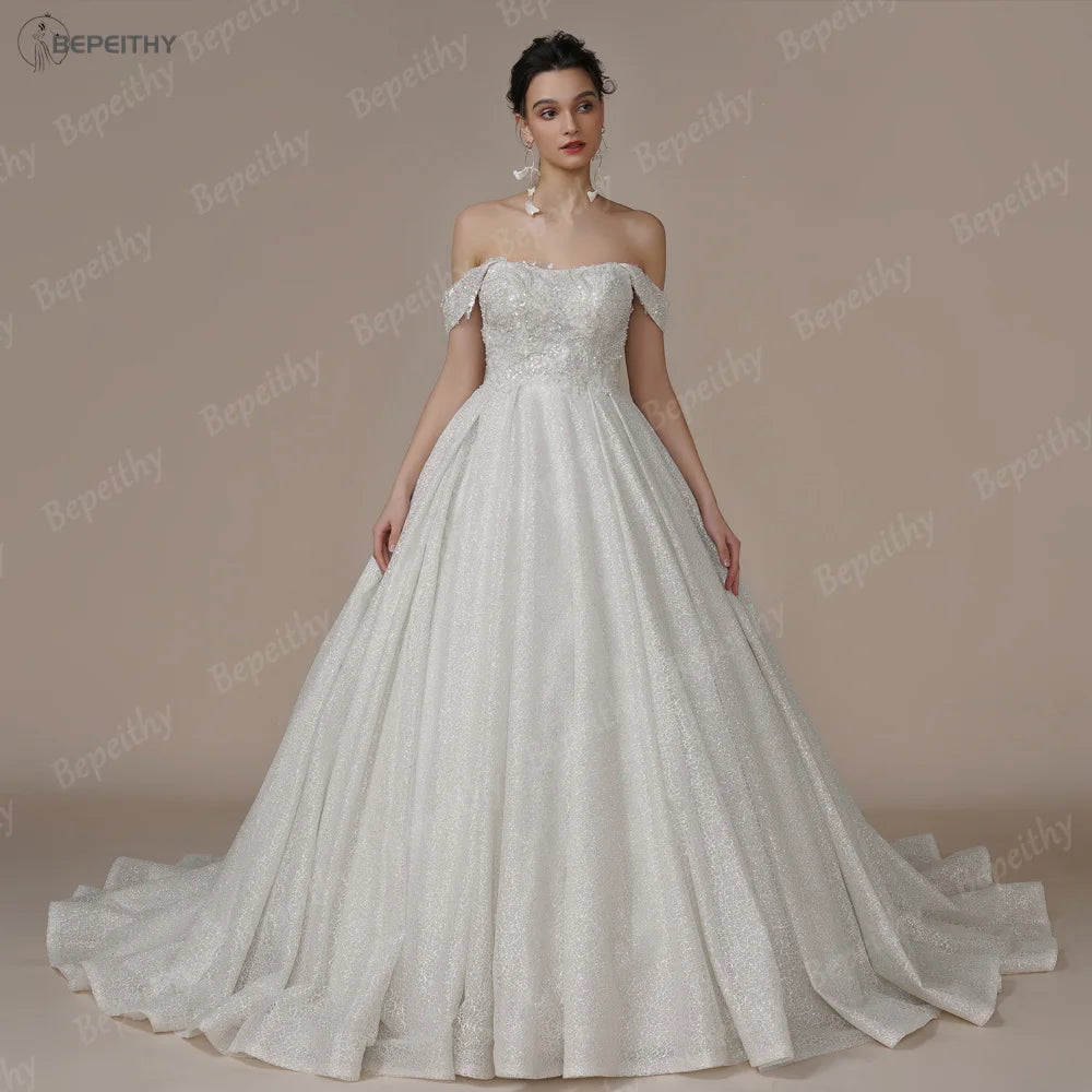 Ivory strapless A-line glitter wedding dress with off-the-shoulder design and bling details, designed by The Clothing Company Sydney