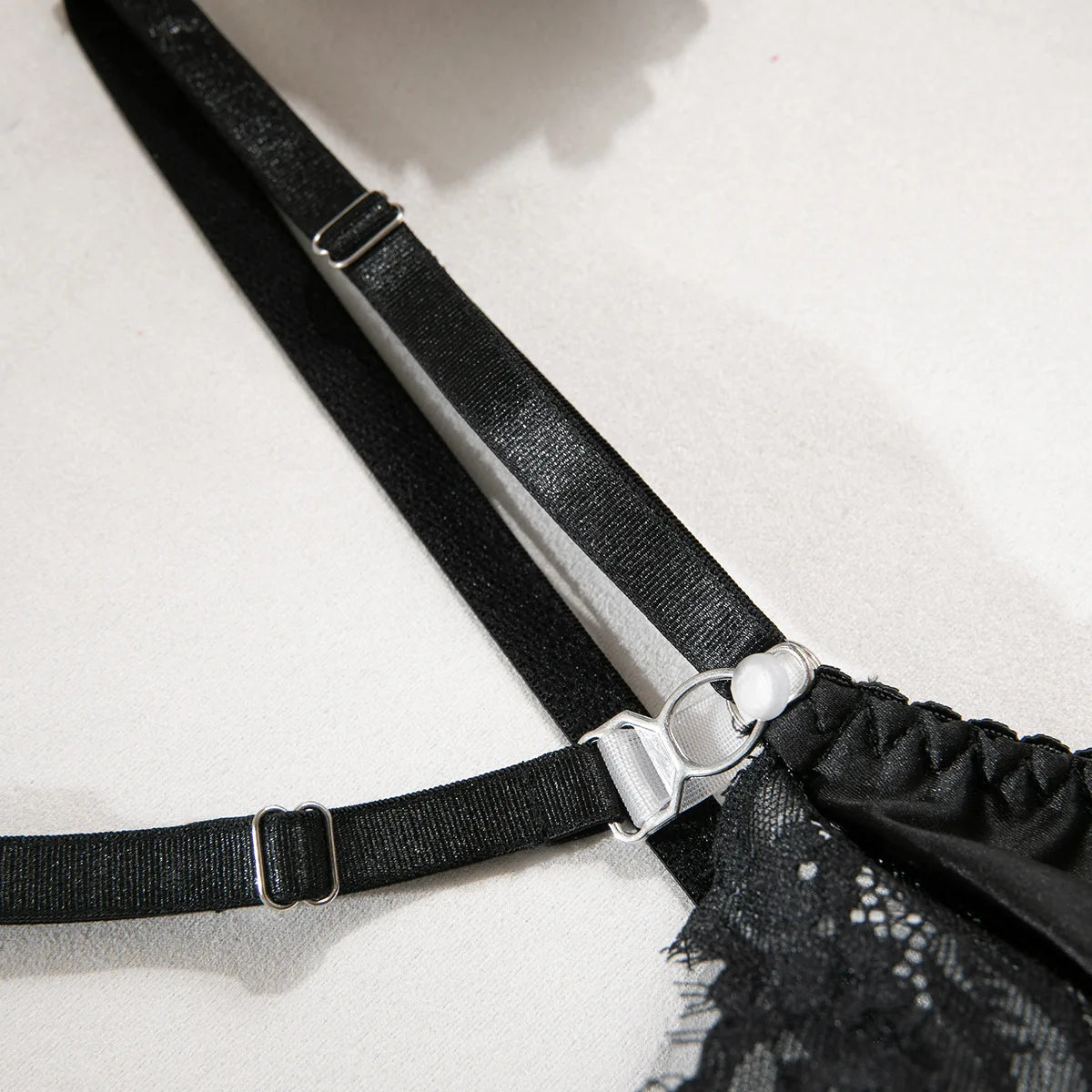 Lace lingerie set featuring a halter bra, heart g-string, and garter belt from The Clothing Company Sydney, with intricate lace details.