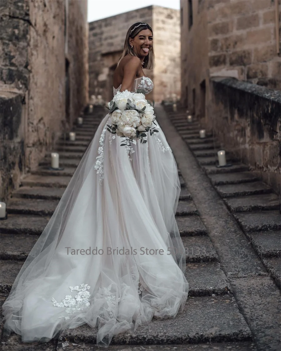 Customized strapless wedding dress with crystal lace appliques and flowing silhouette, perfect for bridal occasions.