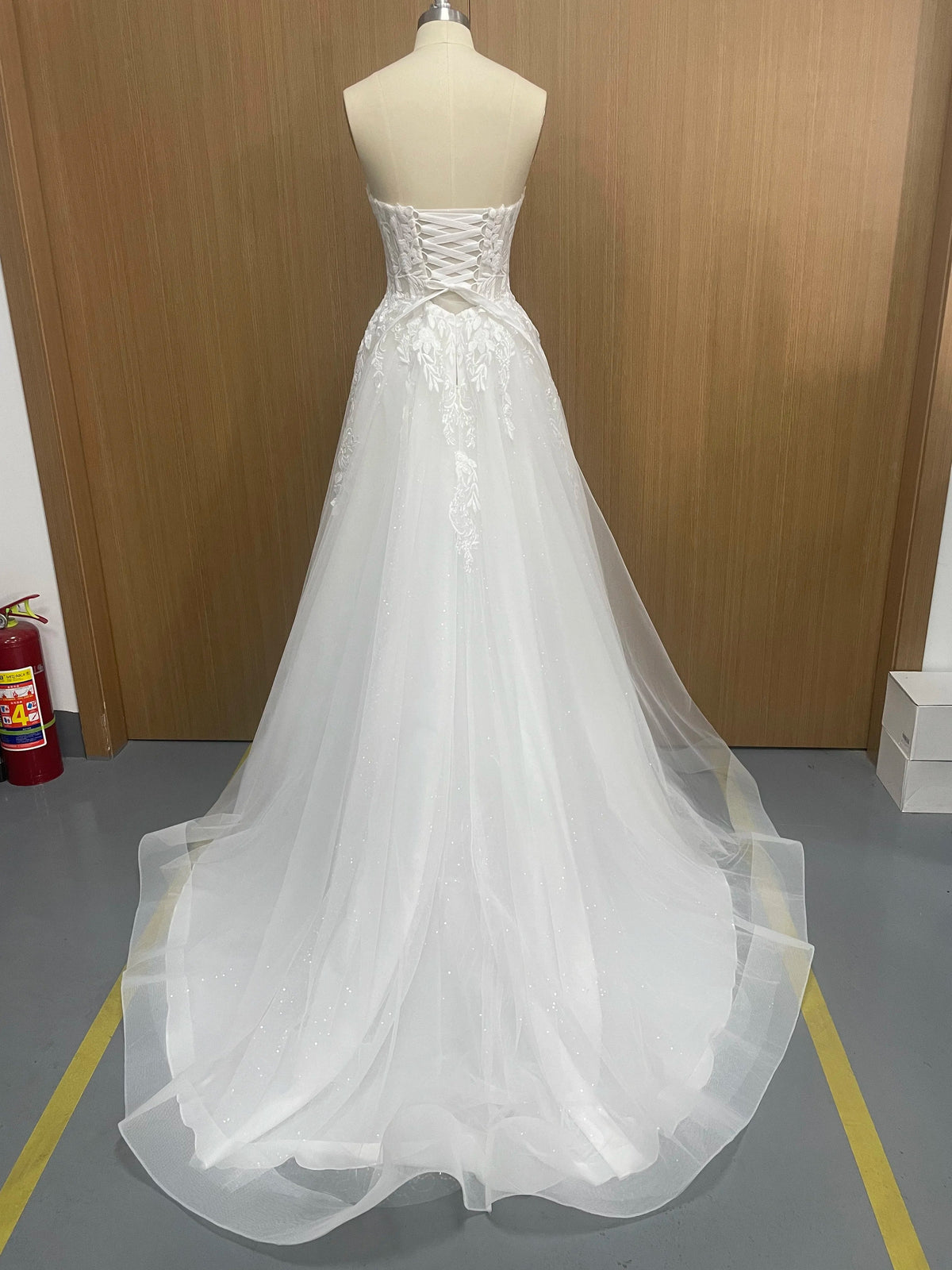 Elegant sleeveless lace wedding dress with deep V-neck and sparkling details, designed by The Clothing Company Sydney.
