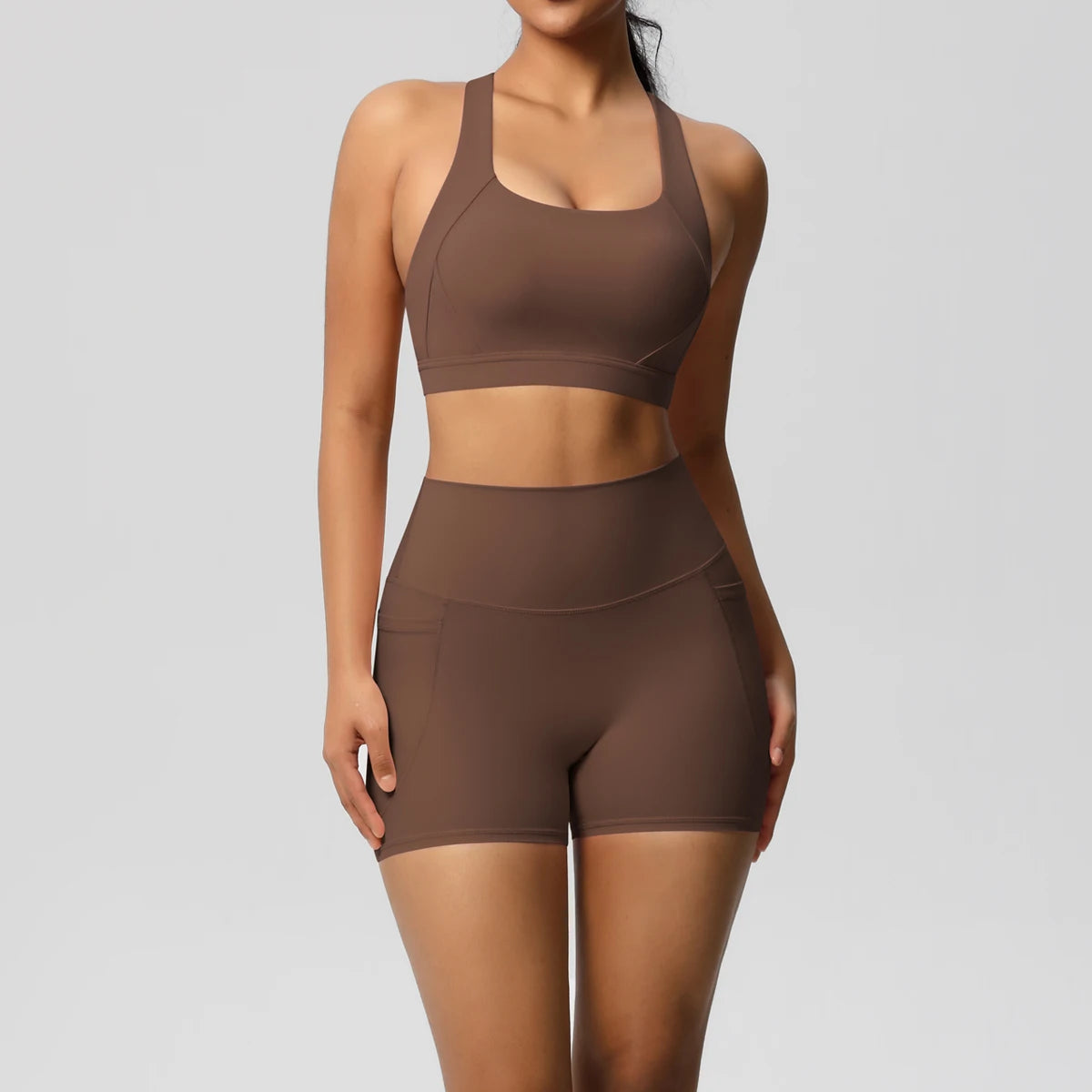 Two-piece women's sportswear yoga set with crossover bra, bike shorts, and leggings, featuring pockets, from The Clothing Company Sydney.