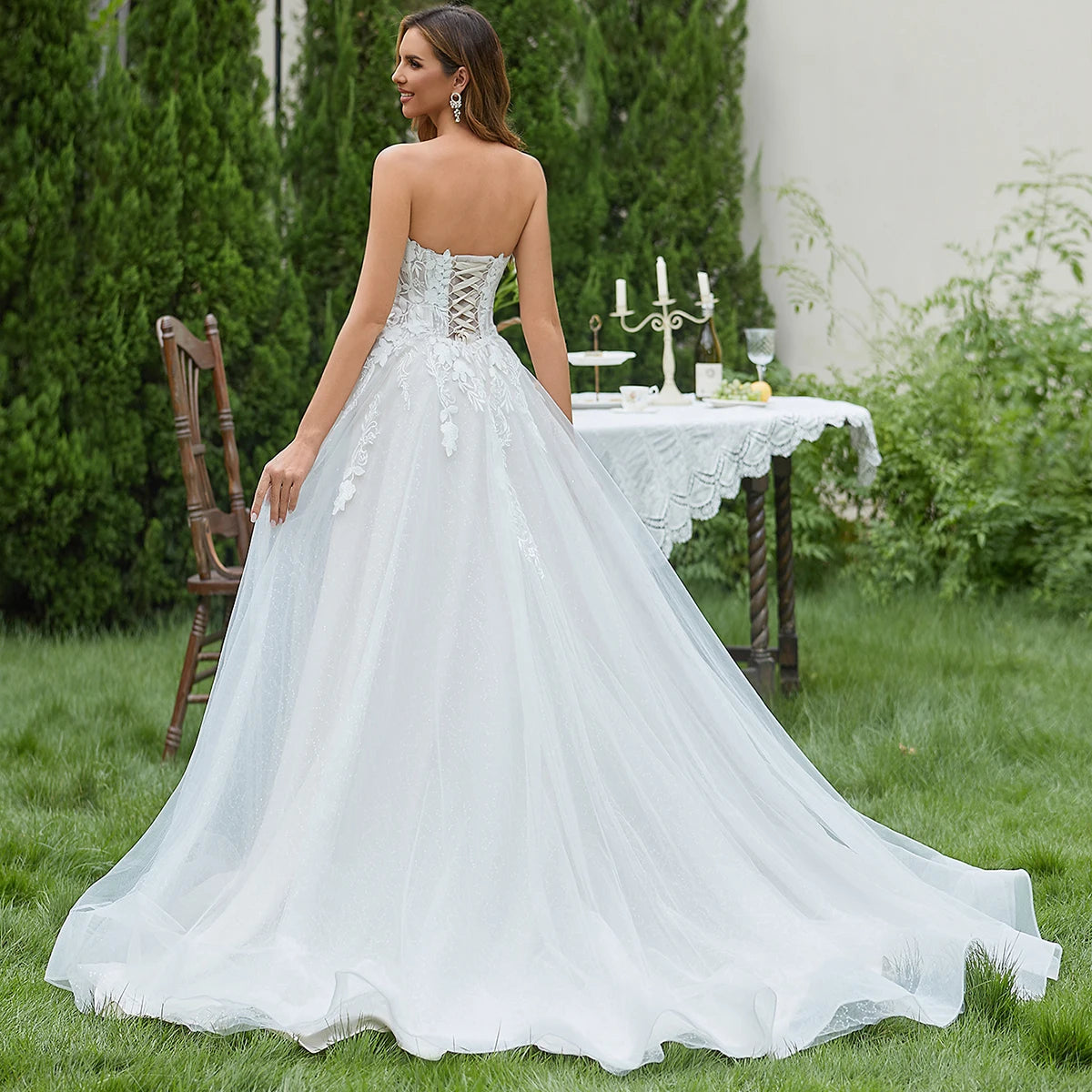 Elegant sleeveless lace wedding dress with deep V-neck and sparkly sweetheart design from The Clothing Company Sydney.