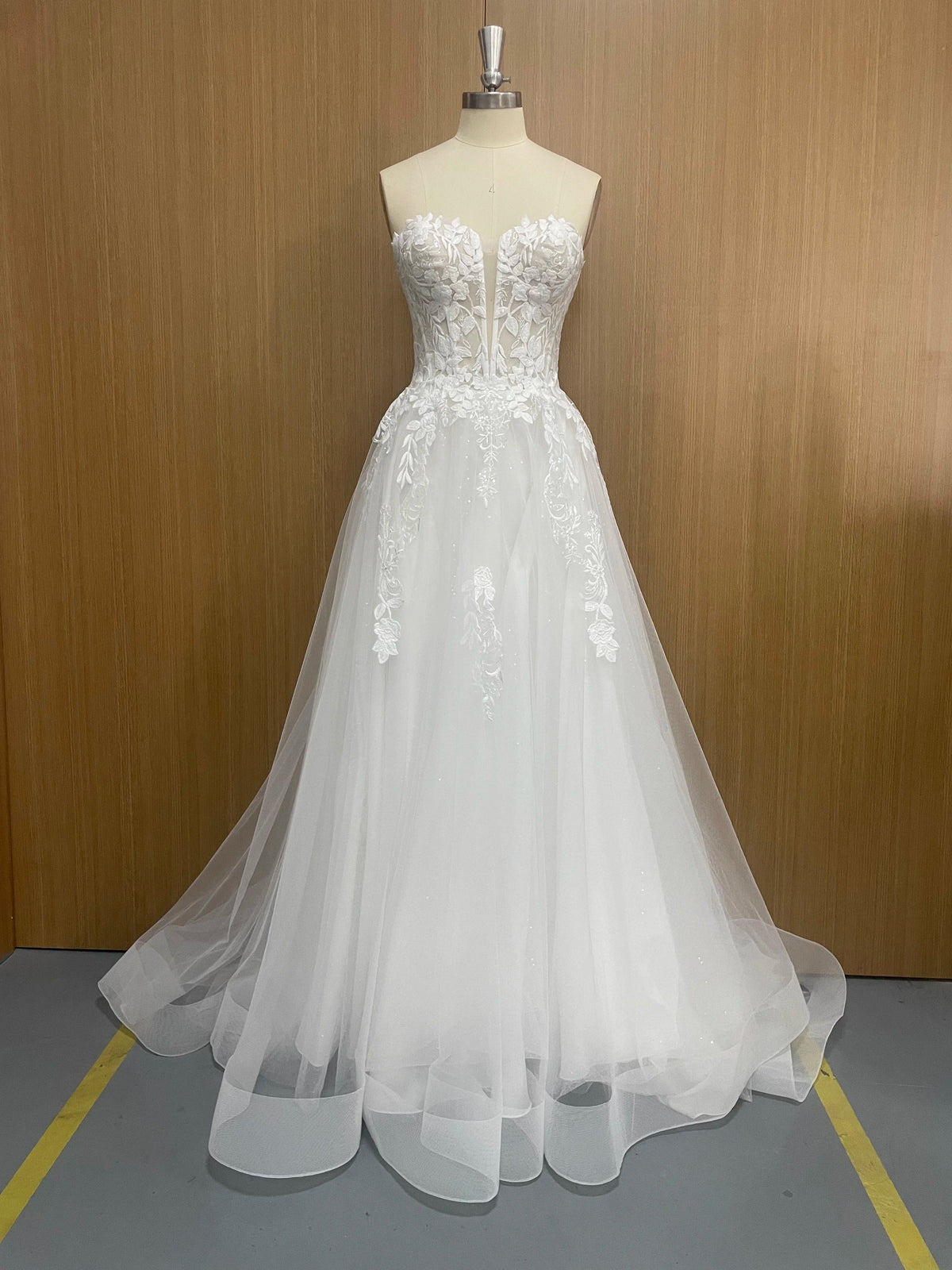 Elegant sleeveless lace wedding dress with deep V-neck and sparkly details, featuring a sweetheart neckline for bridal elegance.
