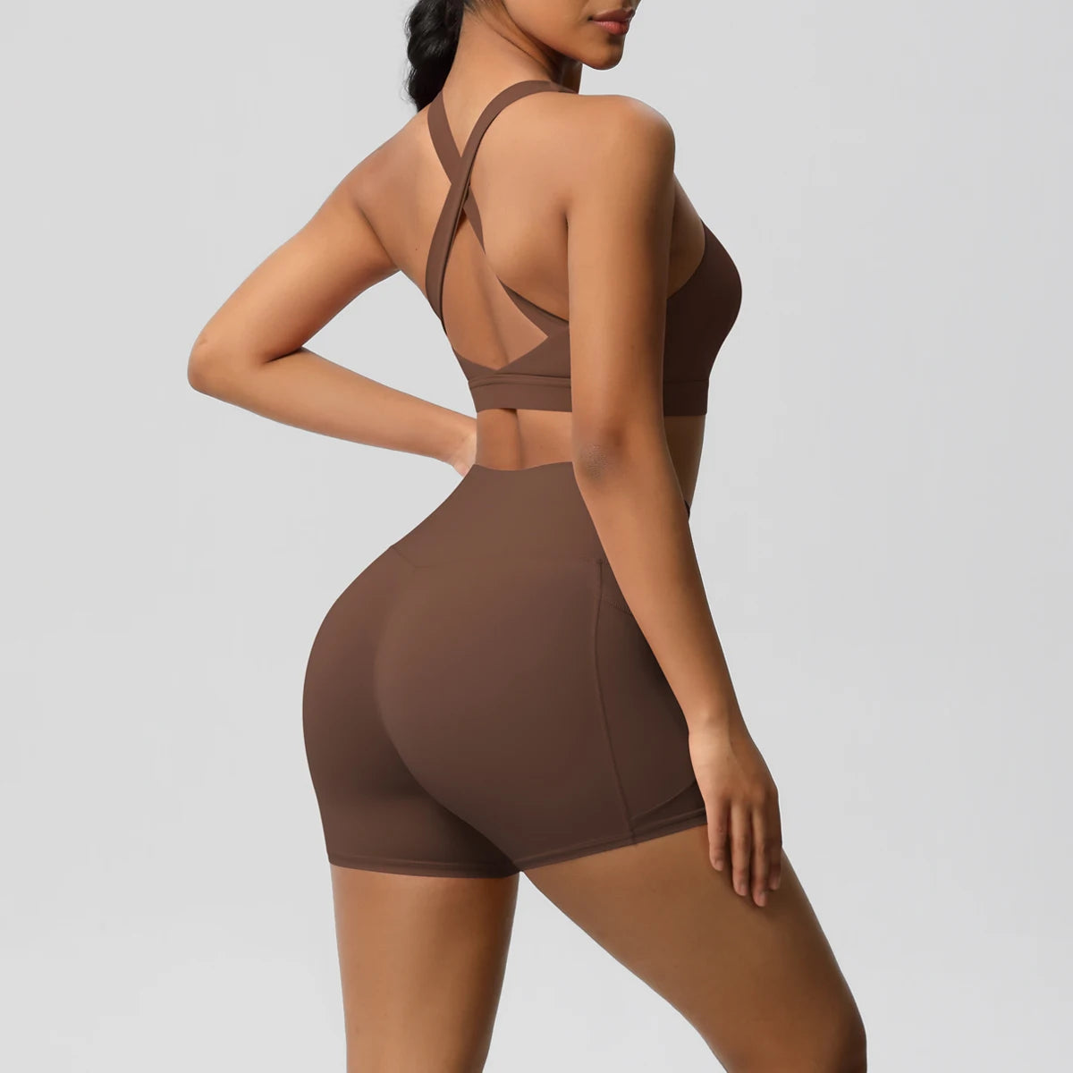 Women’s sportswear set by The Clothing Company Sydney featuring gym shorts, crossover bra, and pocketed leggings for active fitness.
