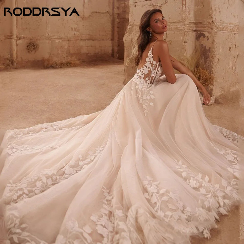 Glitter spaghetti strap boho wedding dress with V-neck, backless design, applique details, and sweeping train by The Clothing Company Sydney.