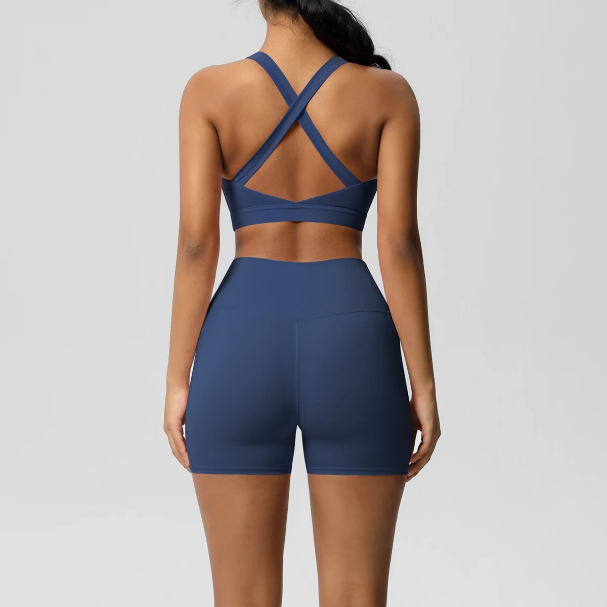 Women’s fitness sportswear set by The Clothing Company Sydney, includes pocketed gym shorts, crossover bra, and leggings for active wear.