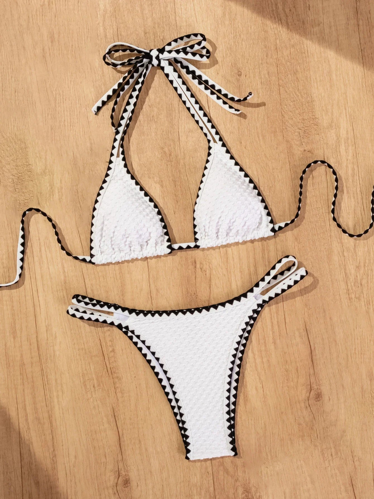 White 2-piece knitted bikini for women with patchwork design, push-up top, thong bottom, perfect for summer beach and swimming.