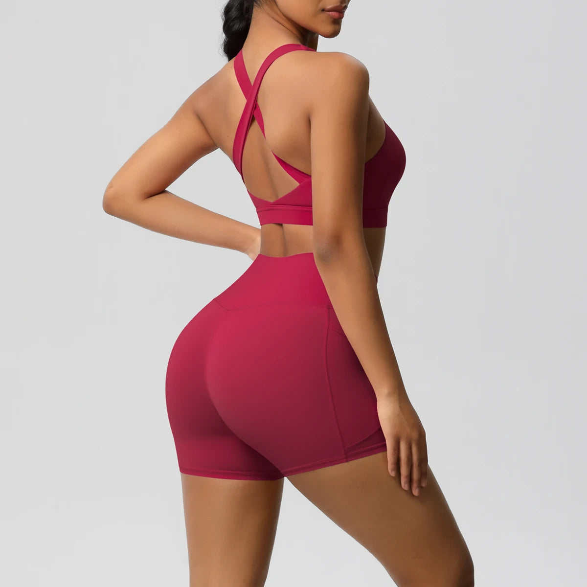 Two-piece women's fitness yoga set with pocketed gym shorts, crossover bra, and leggings from The Clothing Company Sydney.