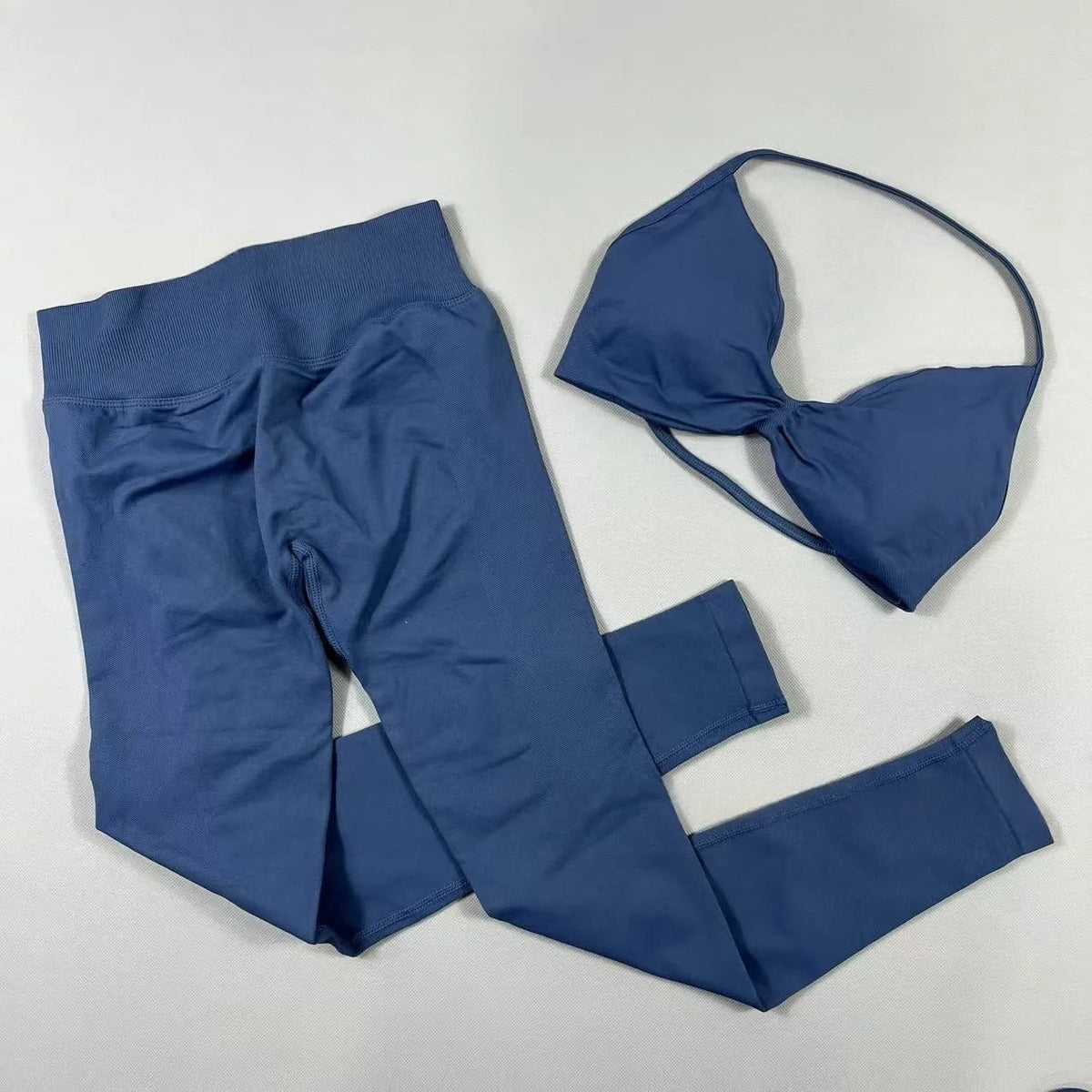 Women's seamless yoga set with halter neck sports bra and high-waisted lifting leggings in two-piece fitness outfit