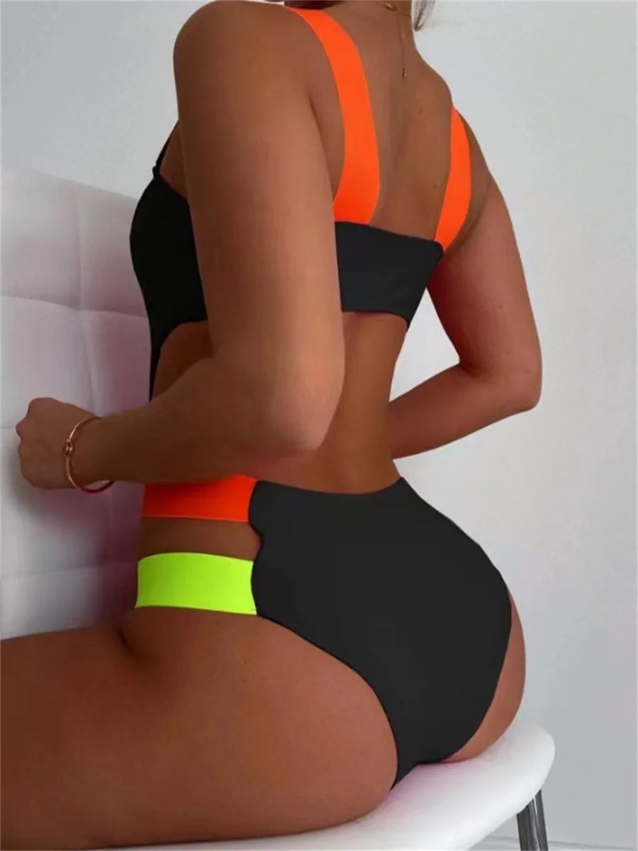 Black contrast one-piece swimsuit with neon straps, hollow-out back, and patchwork design by The Clothing Company Sydney.