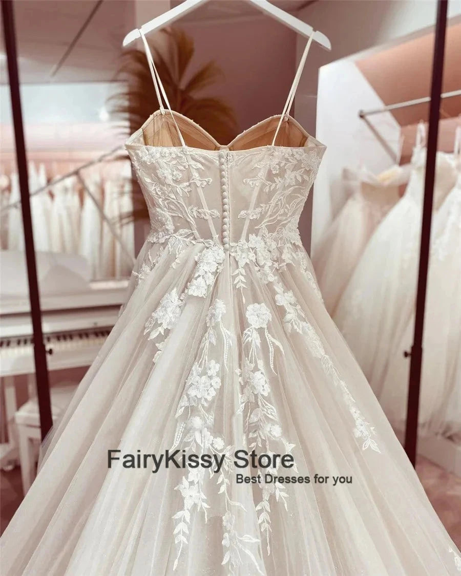 Backless wedding dress with spaghetti straps, mesh see-through fabric, lace details, and exposed boning, by The Clothing Company Sydney.