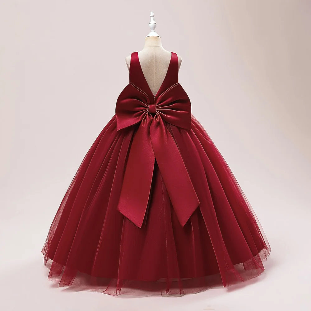 Girls long white bridesmaid and prom gown with a large bow, formal evening dress for weddings, parties, and communions by The Clothing Company Sydney.