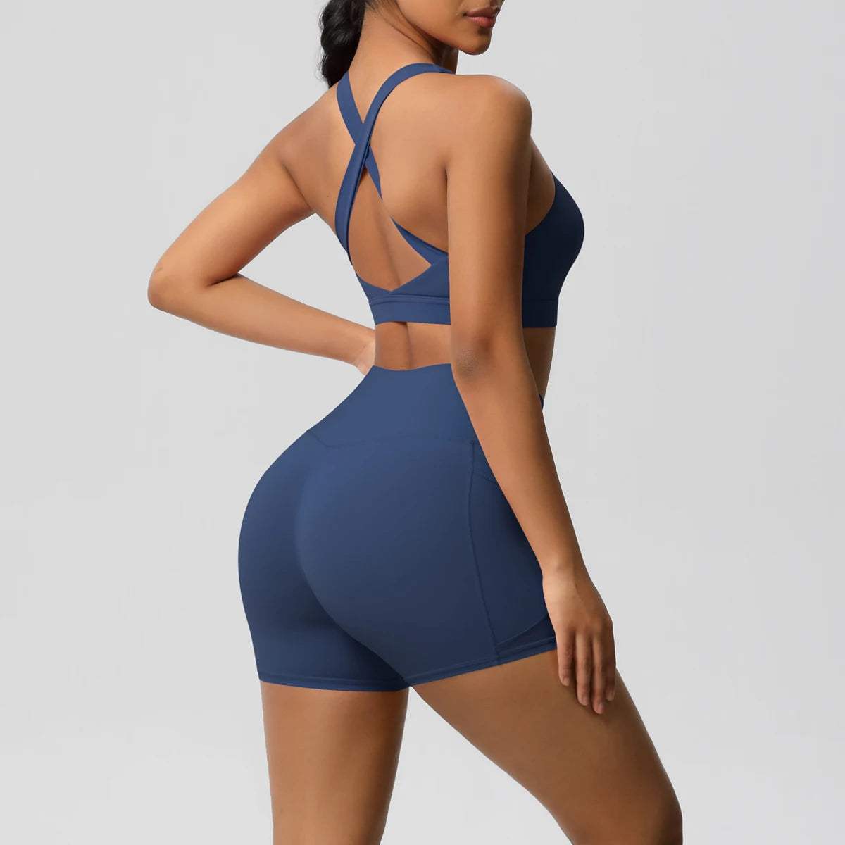 Two-piece women's sportswear yoga set with pocketed gym shorts, crossover bra, and leggings from The Clothing Company Sydney.