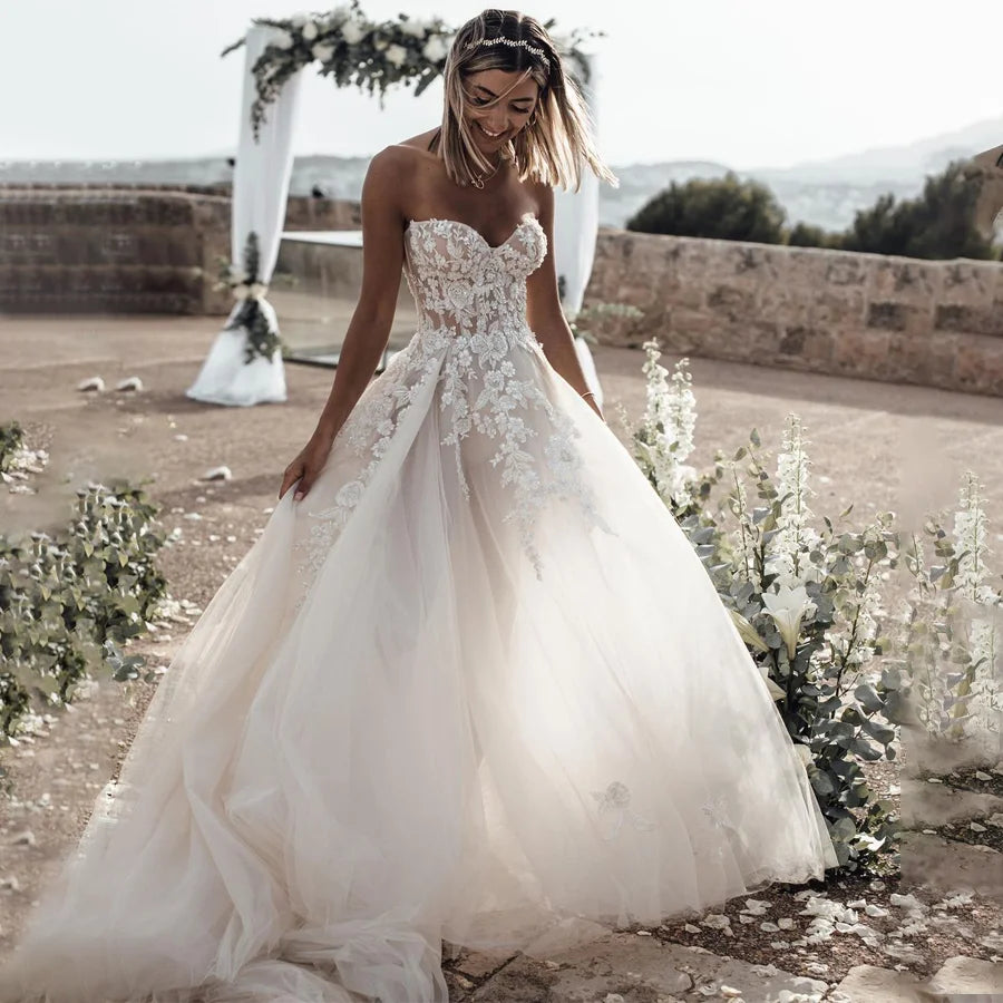 Customized strapless wedding dress by The Clothing Company Sydney with crystal lace appliques and a flowing silhouette.