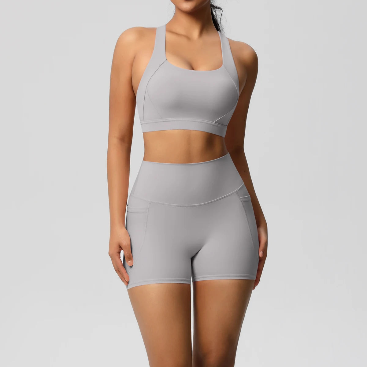 Two-piece women's sportswear yoga set with crossover bra, pocketed gym shorts, and leggings, from The Clothing Company Sydney.