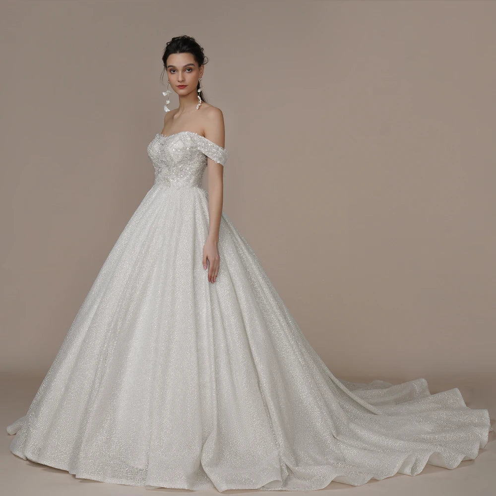 Elegant ivory strapless A-line wedding dress with glitter embellishments, off-the-shoulder design, perfect for brides.