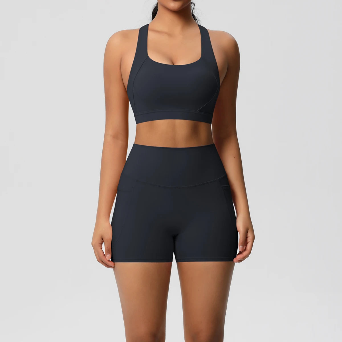 Women’s 2-piece sportswear set by The Clothing Company Sydney, featuring pocketed gym shorts, crossover bra, and leggings for fitness.