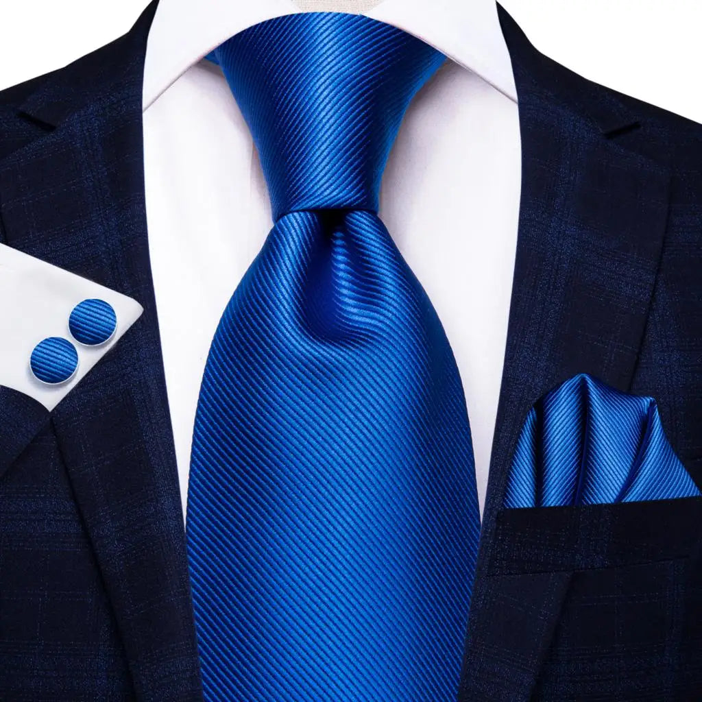 Blue paisley silk tie set for men including necktie, cufflinks, and pocket hanky with intricate paisley pattern and classic accessories.