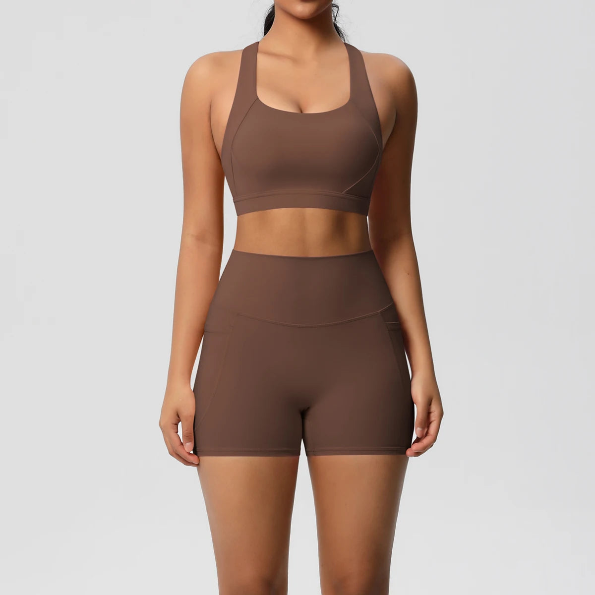 Two-piece women's sportswear yoga set with crossover bra, bike shorts, and leggings, featuring pockets, from The Clothing Company Sydney.