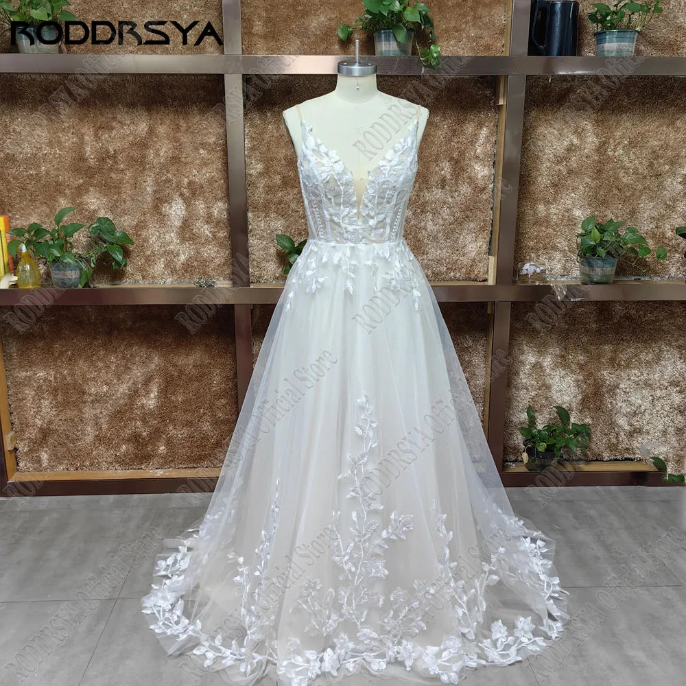 Elegant wedding dress with spaghetti straps, glitter V-neck, backless design, applique details, and a sweep train by The Clothing Company Sydney.