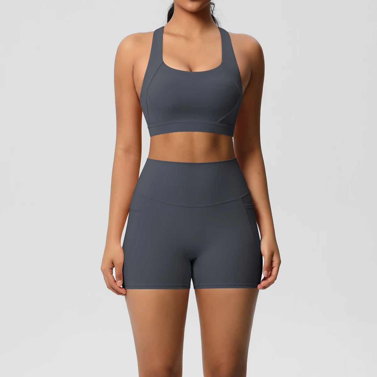 Two-piece women's sportswear yoga set with crossover bra, gym shorts, and leggings featuring pockets, by The Clothing Company Sydney.