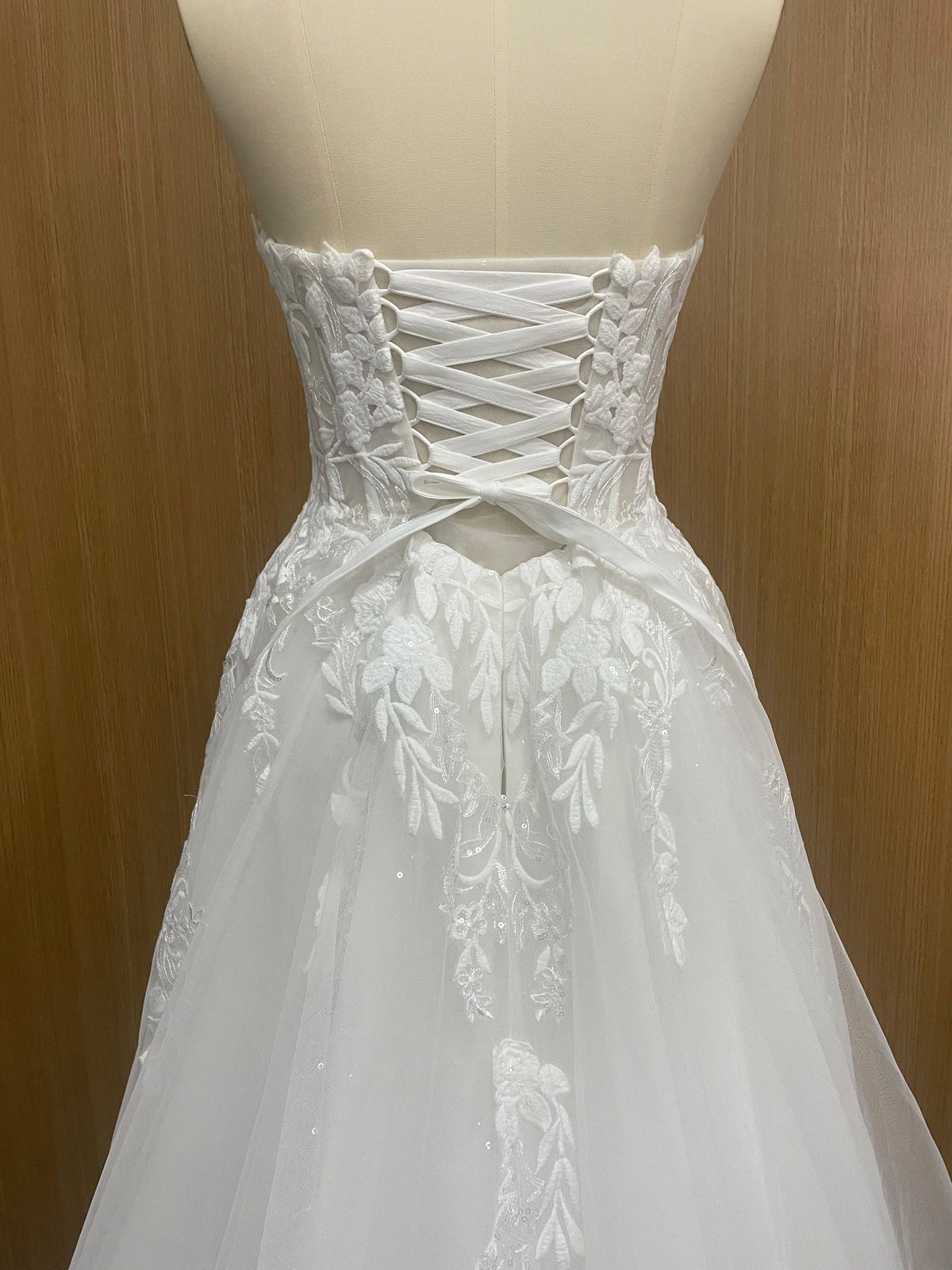 Elegant sleeveless lace wedding dress with deep V-neck and sparkly sweetheart design by The Clothing Company Sydney.